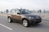 Driving 2013 BMW X5 xDrive50i in Sparkling Bronze Metallic from a front right three-quarter view